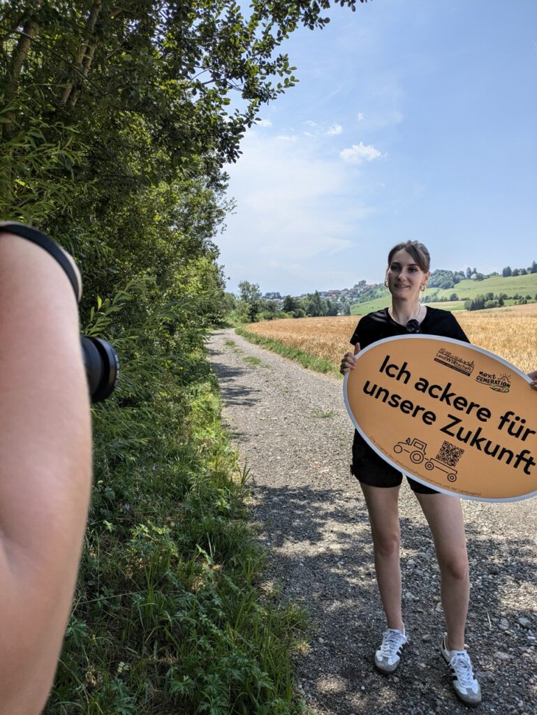 Person mit einem Schild mit Schriftzug Ich ackere für unsere Zukunft